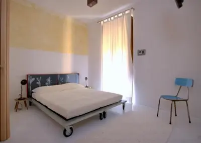 a bedroom with a bed and a chair and a window at A Casa Di Penelope in Rome