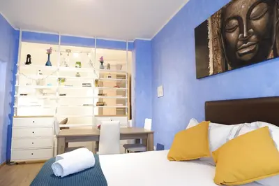 a bedroom with a bed and a desk in it at The Blue Strawberry House in San Giovanni Roma in Rome
