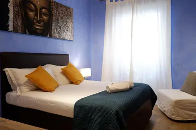 a bedroom with a bed with yellow pillows and a window at The Blue Strawberry House in San Giovanni Roma in Rome
