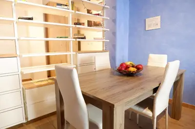 a wooden table with chairs and a bowl of fruit on it at The Blue Strawberry House in San Giovanni Roma in Rome