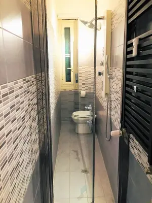 a bathroom with a toilet and a glass door at The Blue Strawberry House in San Giovanni Roma in Rome