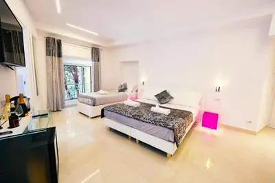 a living room with two beds and a flat screen tv at San Pietro Grand Suite in Rome