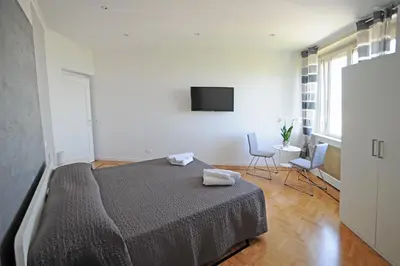 a bedroom with a bed and a tv on the wall at Guest House Vignola in Rome