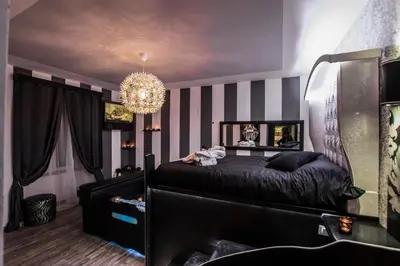 a bedroom with a black bed and a chandelier at Roma d'Amore in Rome