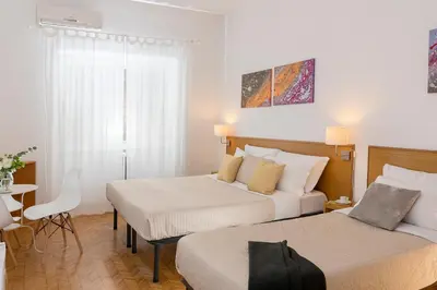a hotel room with two beds and a table at Aurelia 429 Fine Town House in Rome