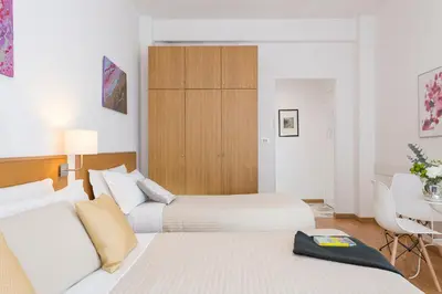 a bedroom with two beds and a table and a cabinet at Aurelia 429 Fine Town House in Rome