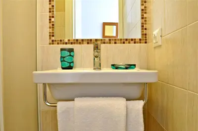 a bathroom with a sink and a mirror and towels at Aurelia 429 Fine Town House in Rome