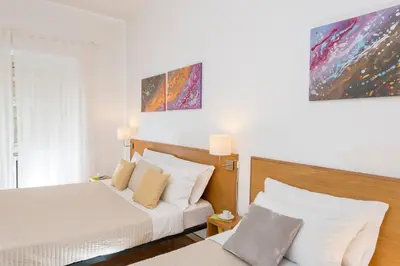 a hotel room with two beds and a window at Aurelia 429 Fine Town House in Rome