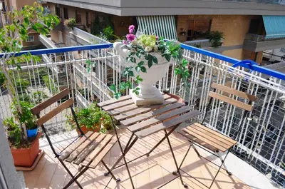 a balcony with two chairs and a vase with flowers at Aurelia 429 Fine Town House in Rome