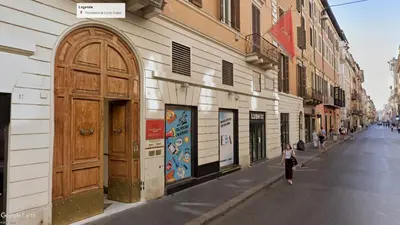 a building with a large wooden door on the side of a street at Residenza Al Corso Suites in Rome