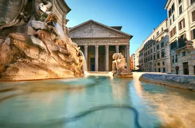 a fountain with a statue in front of a building at Residenza Al Corso Suites in Rome