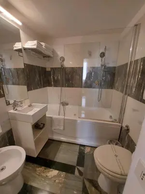a bathroom with a toilet and a tub and a sink at Residenza Al Corso Suites in Rome