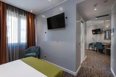 a hotel room with a bed and a flat screen tv at Noba Hotel e Residenze in Rome