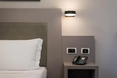 a bedroom with a bed and a phone on a table at Noba Hotel e Residenze in Rome