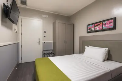 a hotel room with a bed and a television at Noba Hotel e Residenze in Rome
