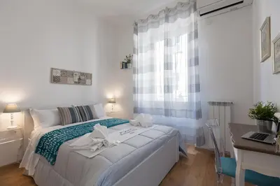 a bedroom with a bed with a desk and a window at Boutique Domus Trastevere Vascellari in Rome