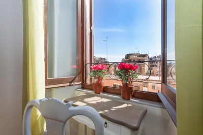 a window with two vases with flowers on a balcony at Boutique Domus Trastevere Vascellari in Rome