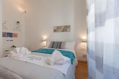 a bedroom with a white bed with towels on it at Boutique Domus Trastevere Vascellari in Rome