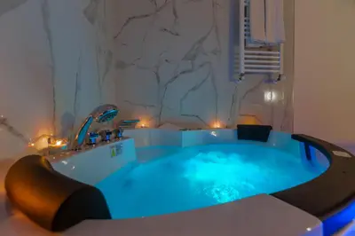 a jacuzzi tub in a bathroom with blue lighting at Miss Suite in Rome