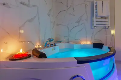 a bathroom with a large tub with a candle and a sink at Miss Suite in Rome