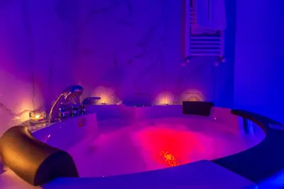 a jacuzzi tub in a room with purple lights at Miss Suite in Rome