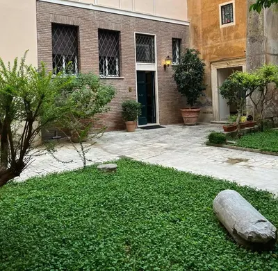 a house with a yard of green grass and a building at Lovatelli Home al Campidoglio in Rome