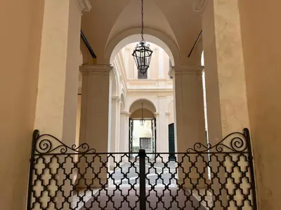 a hallway in a building with a chandelier at Lovatelli Home al Campidoglio in Rome