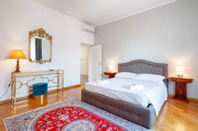 a bedroom with a large bed and a red rug at HT Residence Maximus in Rome