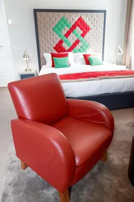 a red chair in a bedroom with a bed at HT Residence Maximus in Rome