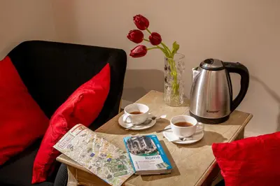 a table with two cups of coffee and a vase with flowers at Avignonesi Suites - CA Domus Collection in Rome