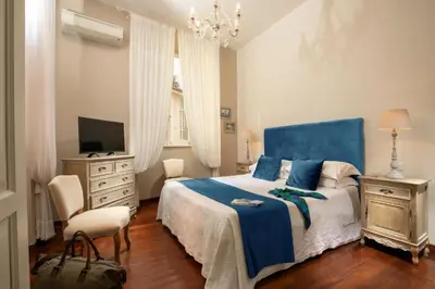 a bedroom with a blue bed and a television at Avignonesi Suites - CA Domus Collection in Rome