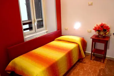 a bedroom with two beds and a vase of flowers on a table at Legends in Rome