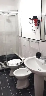 a bathroom with two toilets and a shower and a sink at Legends in Rome