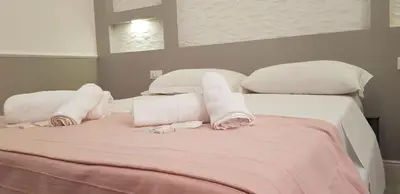 a white bed with towels and pillows on it at Legends in Rome