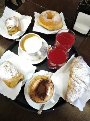 a tray of pastries and cups of coffee and donuts at Nice Rome Holiday in Rome