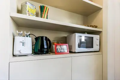 a kitchen counter with a microwave and appliances on it at GuestHost - Palazzo Borghese Lovely Flat in Rome