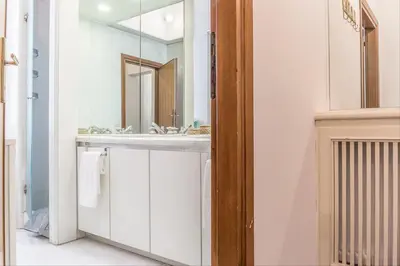 a bathroom with a white sink and a mirror at GuestHost - Palazzo Borghese Lovely Flat in Rome