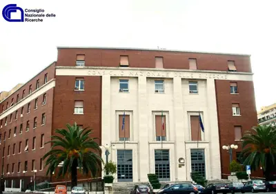 a large brick building with palm trees in front of it at Casa Vacanza Marrucini in Rome