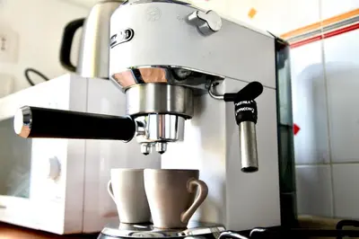 a coffee machine pouring coffee into cups on a counter at Casa Vacanza Marrucini in Rome