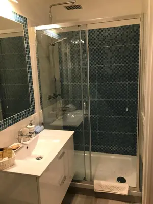 a bathroom with a shower and a sink and a glass shower stall at Rome Veniero WelcomeHouse in Rome
