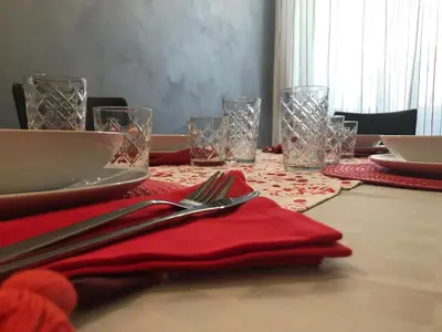 a table with a red napkin and forks and glasses at Rome Veniero WelcomeHouse in Rome