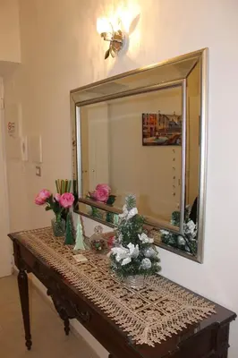 a large mirror on a table with flowers on it at Rome Veniero WelcomeHouse in Rome