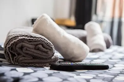 a towel and socks and a remote control on a table at La Residenza City in Rome