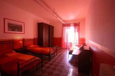 a red room with two beds and a window at Tatusa al Colosseo in Rome