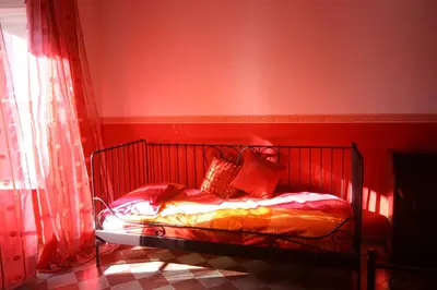 a red bedroom with a bed with red walls at Tatusa al Colosseo in Rome