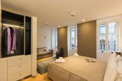 a bedroom with a large bed and a couch at Amazing Piazza Venezia Suites in Rome