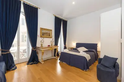 a bedroom with a bed and a chair and a window at Amazing Piazza Venezia Suites in Rome