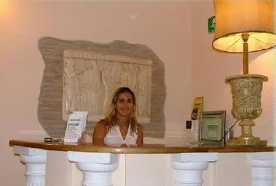 a woman sitting at a table in a room at Hotel Panda in Rome