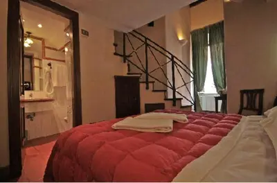 a bedroom with a red bed and a staircase at Hotel Panda in Rome
