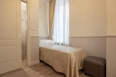 a small bedroom with a bed and a window at Hotel Flavia in Rome